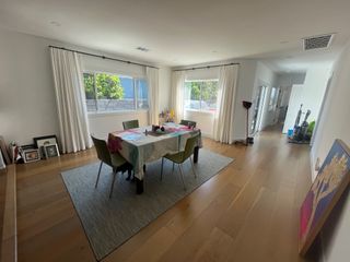 A dining room with a gray rug and a small dining table