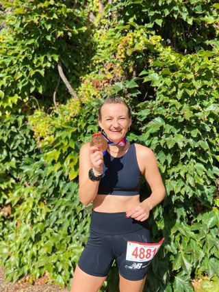 Strength training for running: Ally at the finish line with her medal