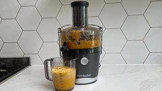 Nutribullet Juicer on a kitchen countertop with oranges that have been juiced