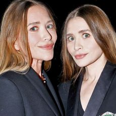 Ashley and Mary-Kate Olsen wearing matching black coats at the 2025 CFDA Awards in New York City.