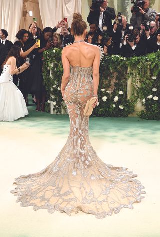A back shot of Jennifer Lopez in a sheer, crystal Schiaparelli gown at the 2024 Met Gala