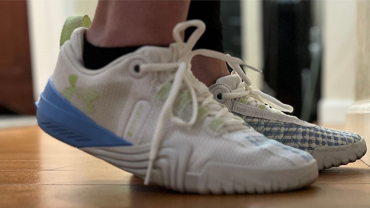 feet inside Under Armour Reign 6 shoes on a wooden floor shot side on
