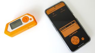 A Flipper Zero device next to a smartphone running the Flipper app