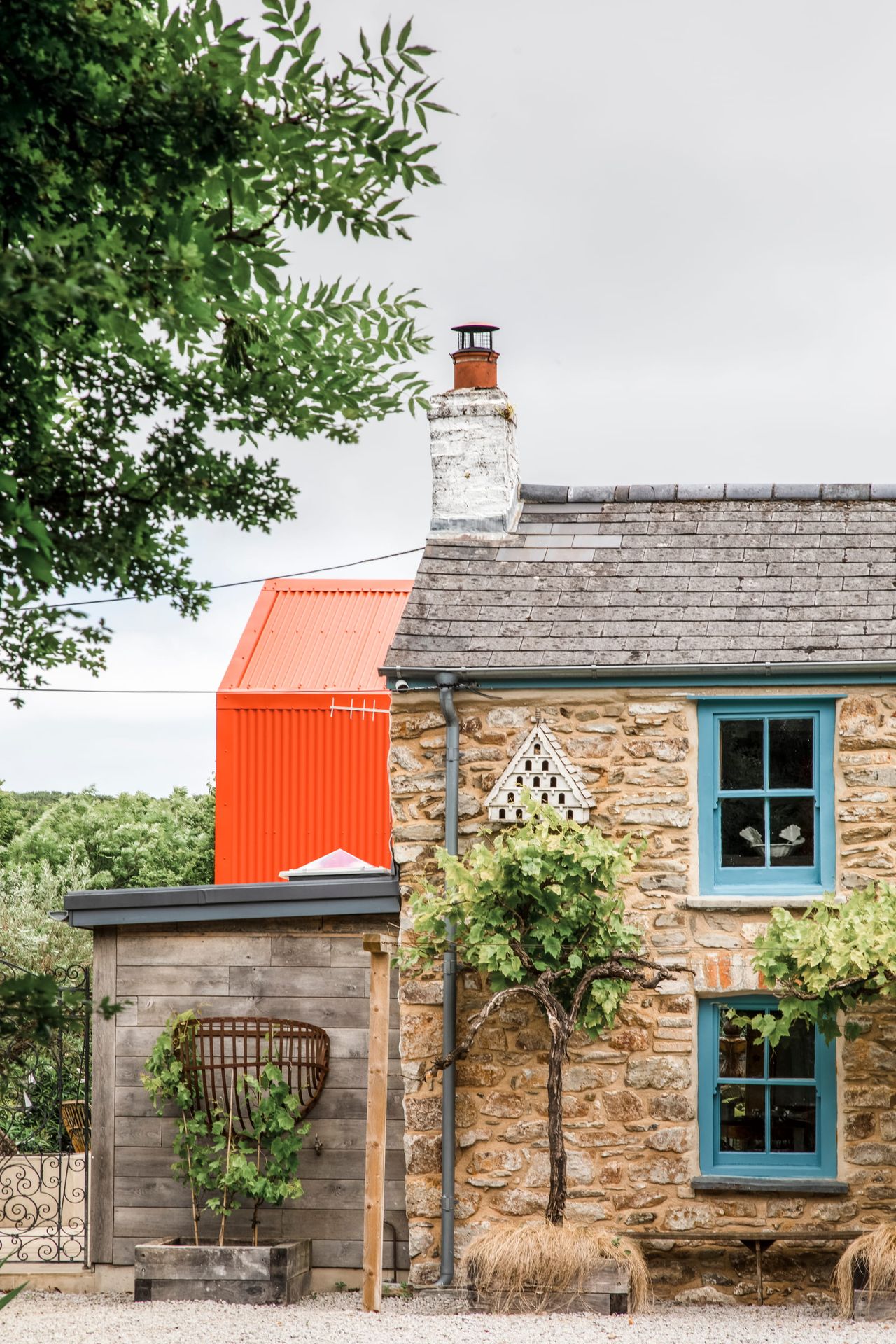 Cornish cottage with blue painted windows and a modern orange extension