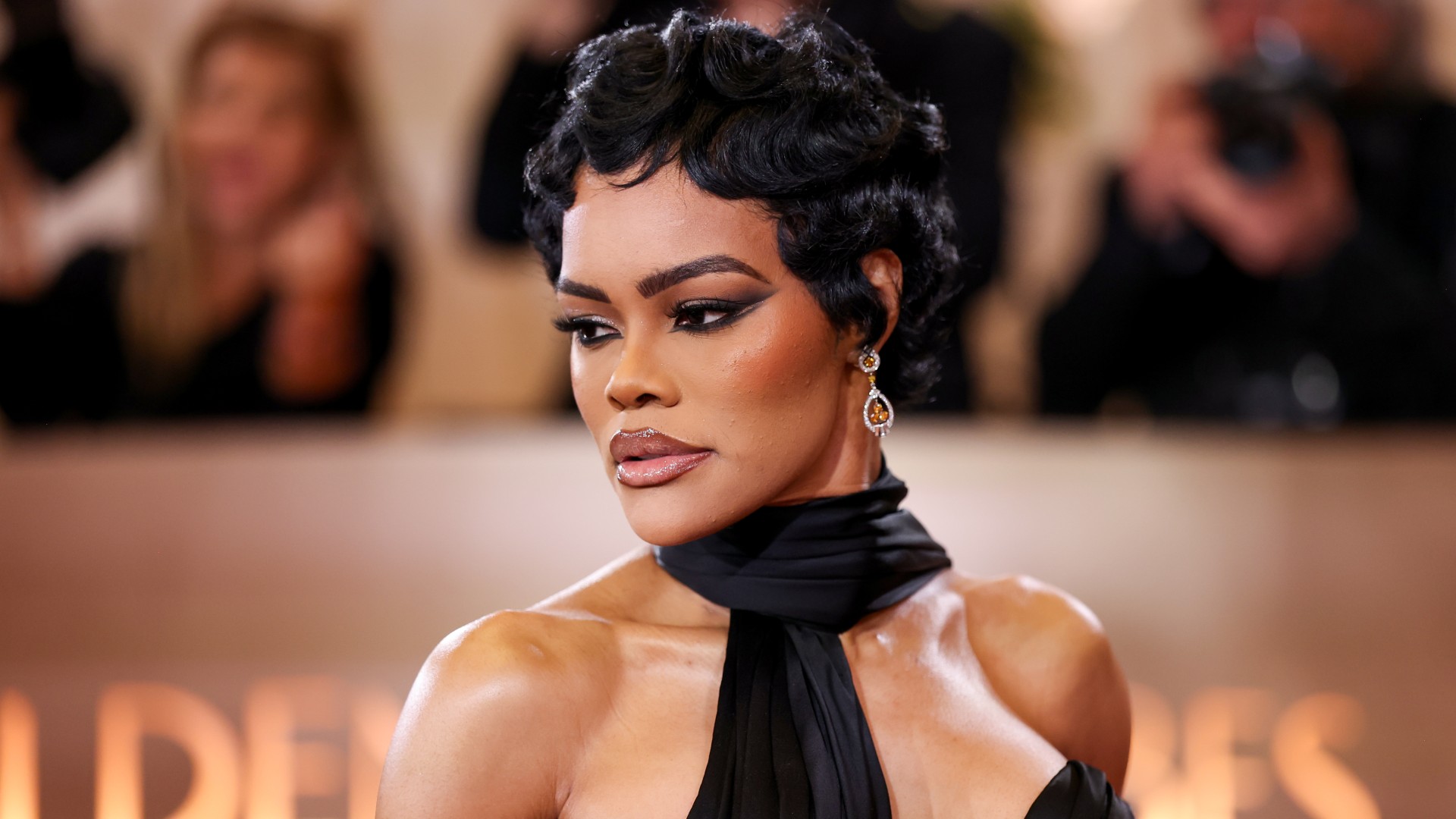 a black woman with short hair poses for a photo at a red carpet event