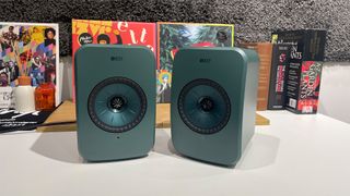 Green KEF LSX II LT on a table in front of books