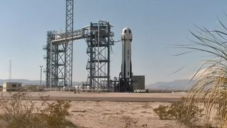 A blue, white and black Blue Origin rocket stands in the Texas desert ready for launch on Oct. 7, 2024.