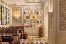 An eccentrically conceived hotel lobby is filled with artifacts, coffee table books, and ceramics, as well as being decorated with plush textiles and wall accents.