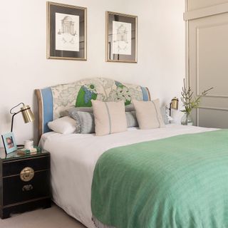 bedroom with upholstered bed and green blanket