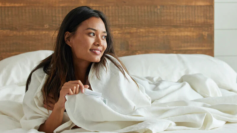 Woman in bed with Avocado white hemp sheets