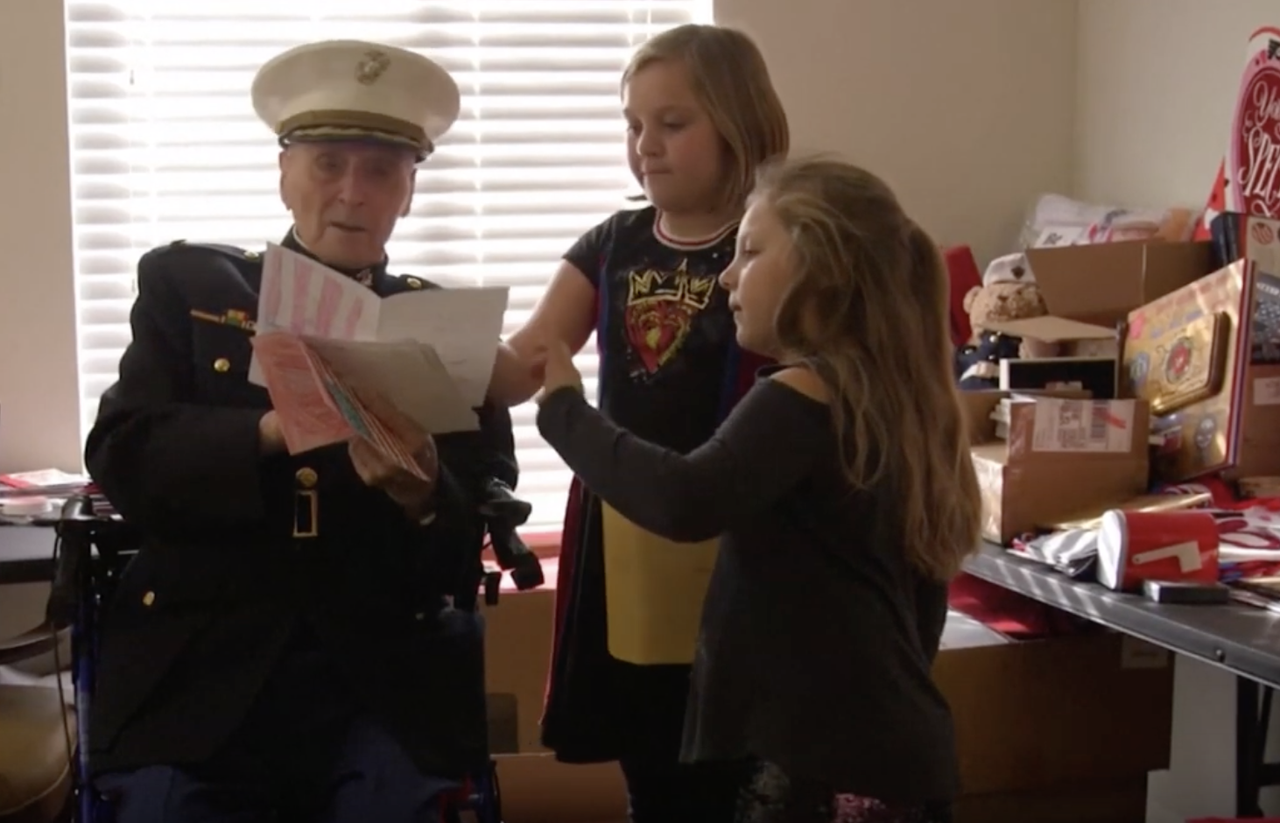 William White and his great-granddaughters read cards.