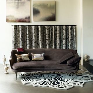 living area with dark brown velvet sofa and rug