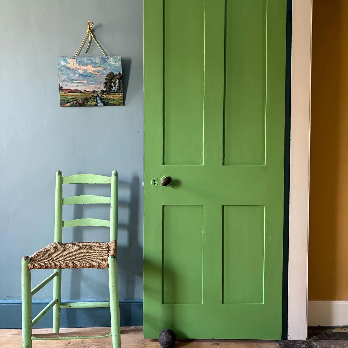 green internal door open next to a blue wall