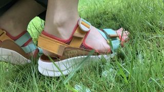 Foot wearing sandals in the grass
