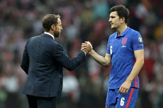 England manager Gareth Southgate shakes hands with defender Harry Maguire after a game against Poland in 2021.