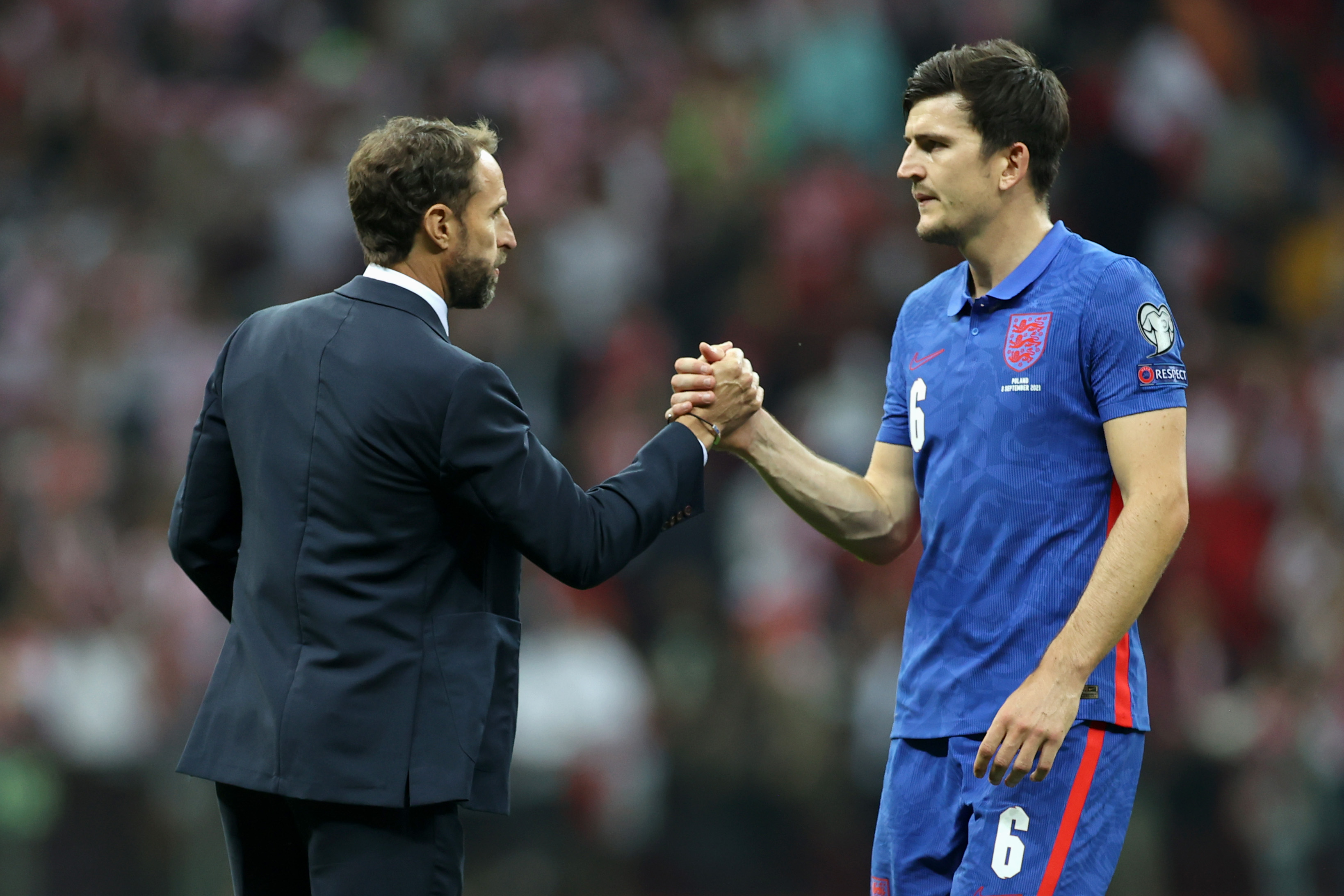 England manager Gareth Southgate shakes hands with defender Harry Maguire after a game against Poland in 2021.