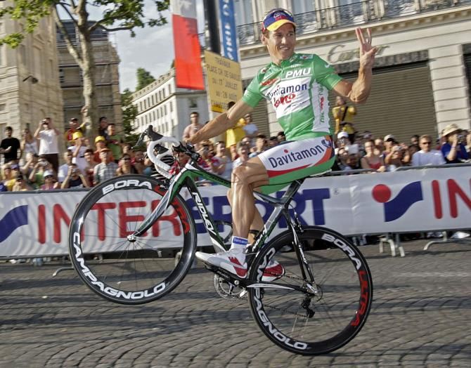 Robbie McEwen does a wheelie to celebrate his green jersey victory