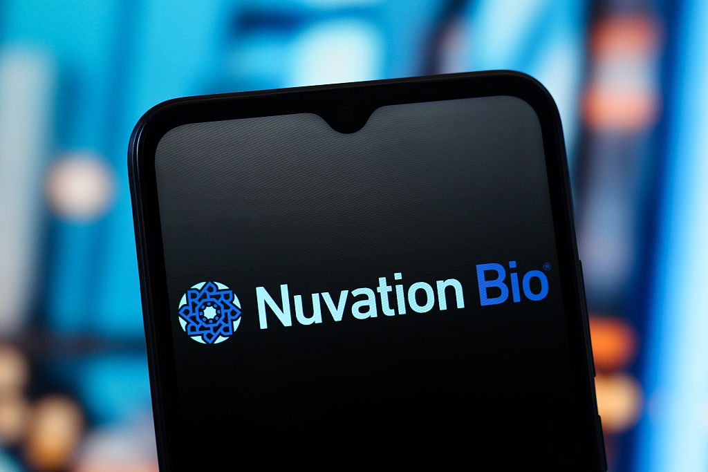 Nuvation Bio logo on a smartphone with blue lights blurred in the background