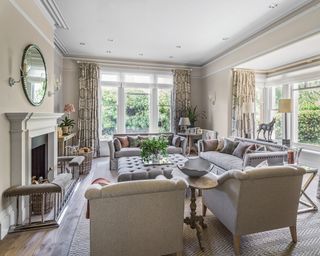 A living room with grey sofa. beige walls and traditional style fireplace