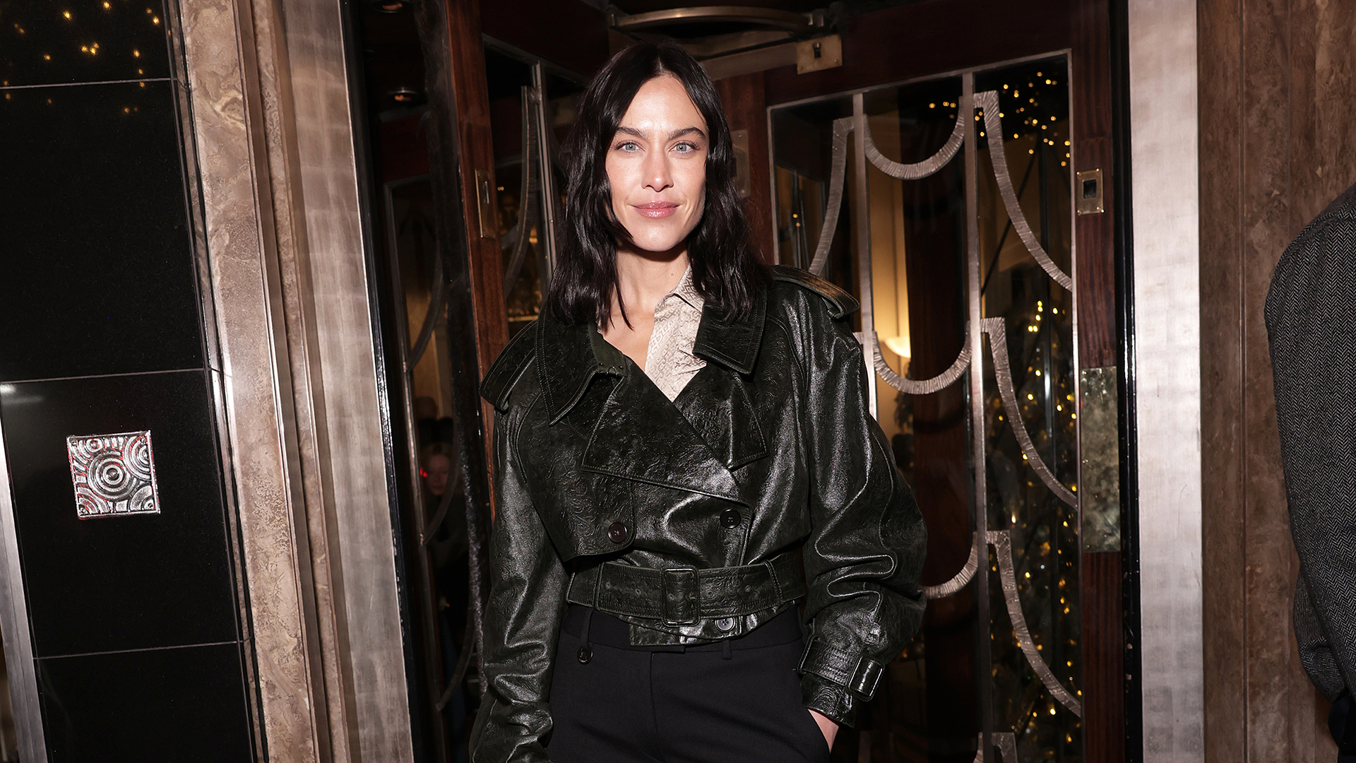 Alexa Chung wearing a cropped leather trench with flared pants and pointed-toe shoes