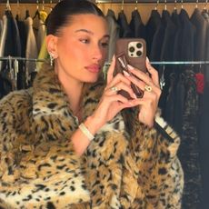 Hailey Bieber in her closet wearing a leopard print fur jacket.
