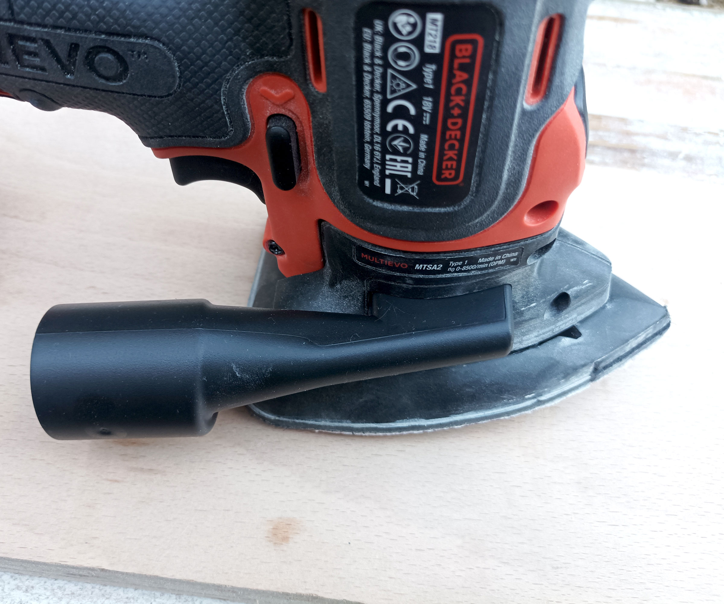 Close up of Black and Decker sander attachment on plywood