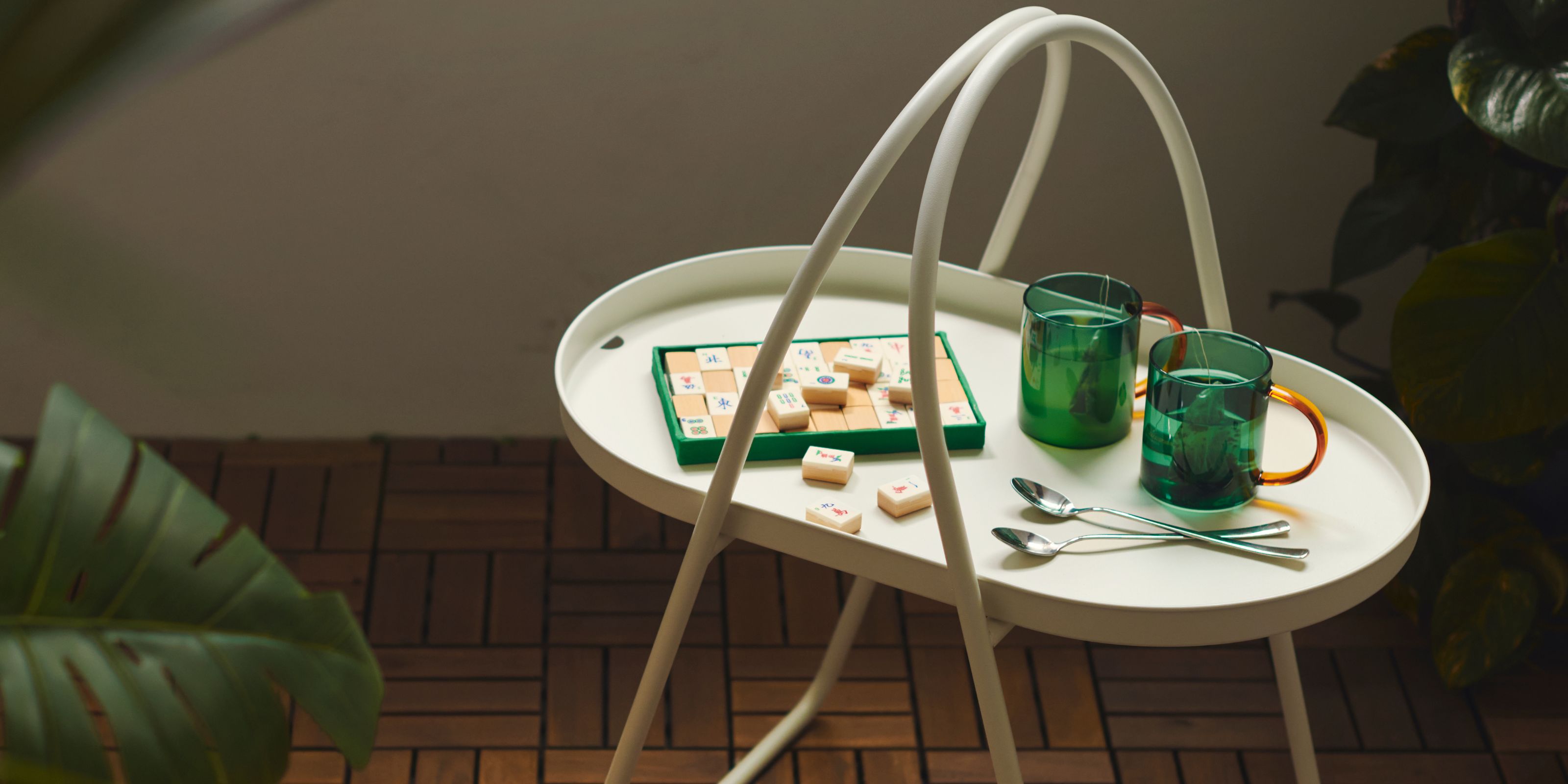 IKEA's portable coffee table on a balcony with a game and green mugs on top of it