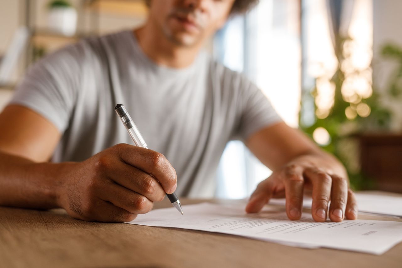 Man at desk signing paper