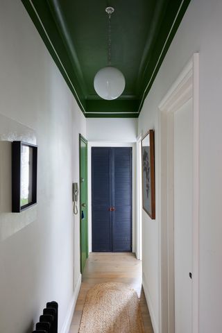 a hallway with a green painted ceiling