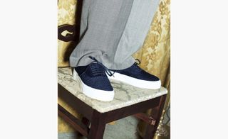 View of grey trousers and sneakers standing on a chair