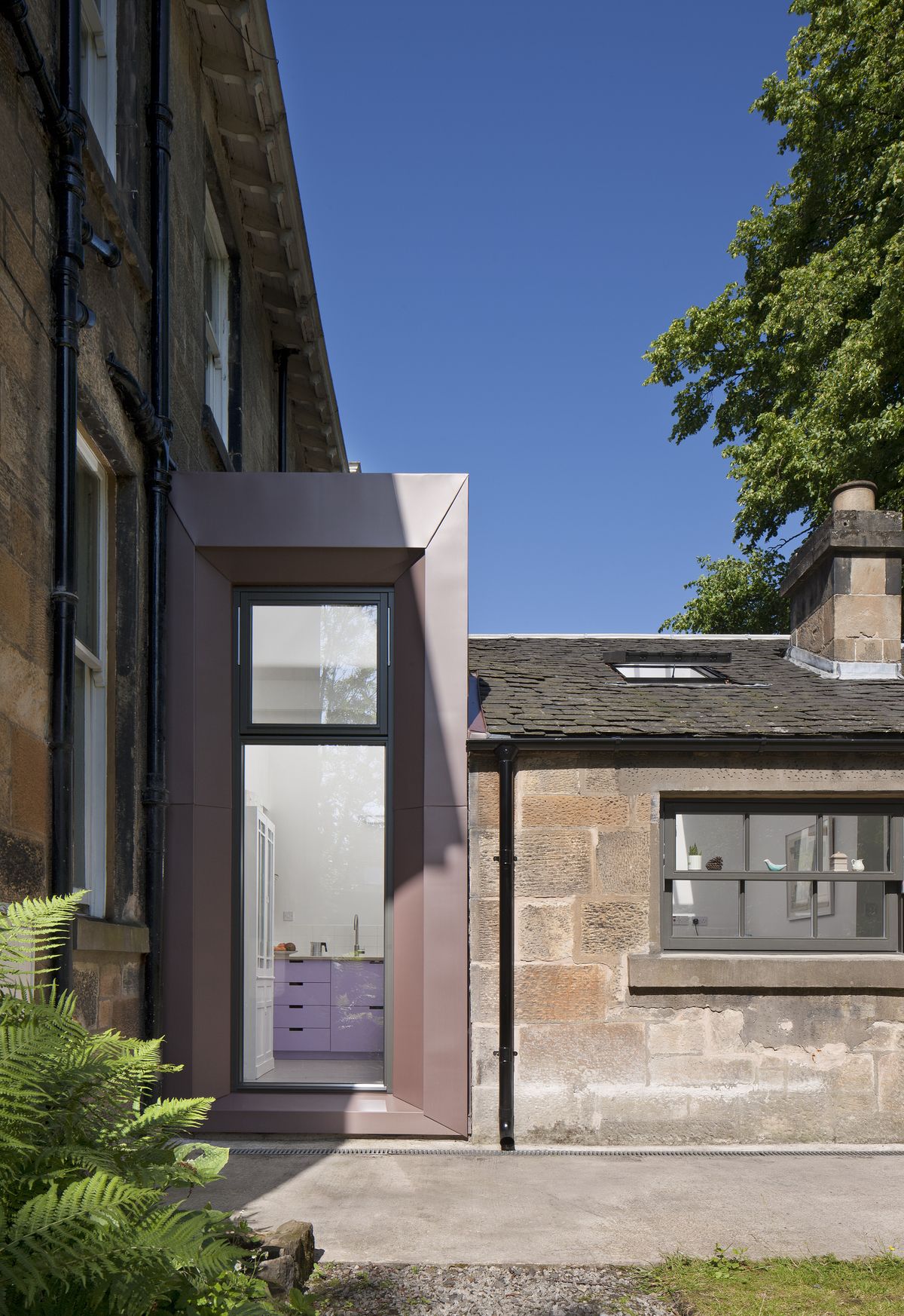 A simple, low-maintenance palette of materials was used, with the copper-toned zinc of the dormer and the warm grey aluminium-clad windows chosen to complement the blonde sandstone of the original Victorian structure.