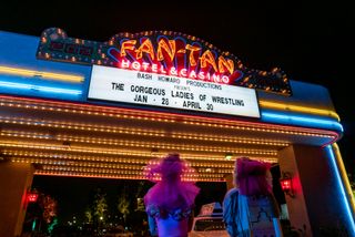 Debbie and Ruth seen from behind, looking at the casino marquee in Glow Season 3
