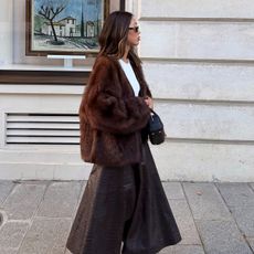 Aimee Song wearing a brown fur coat and leather midi skirt