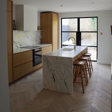 kitchen with wood cabinetry and island unit with marble worktops