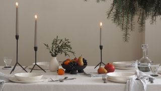 a dinner table set with fruit in a bowl