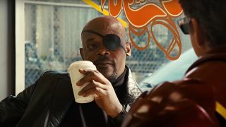 Samuel L Jackson leans back while drinking his coffee in Iron Man 2.