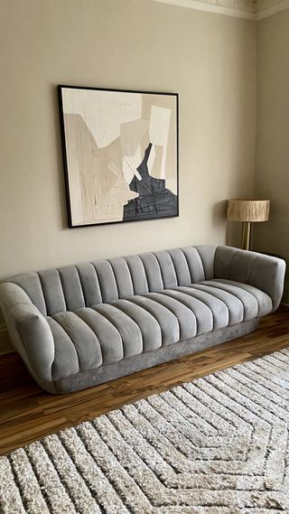 A living room with a grey velvet sofa