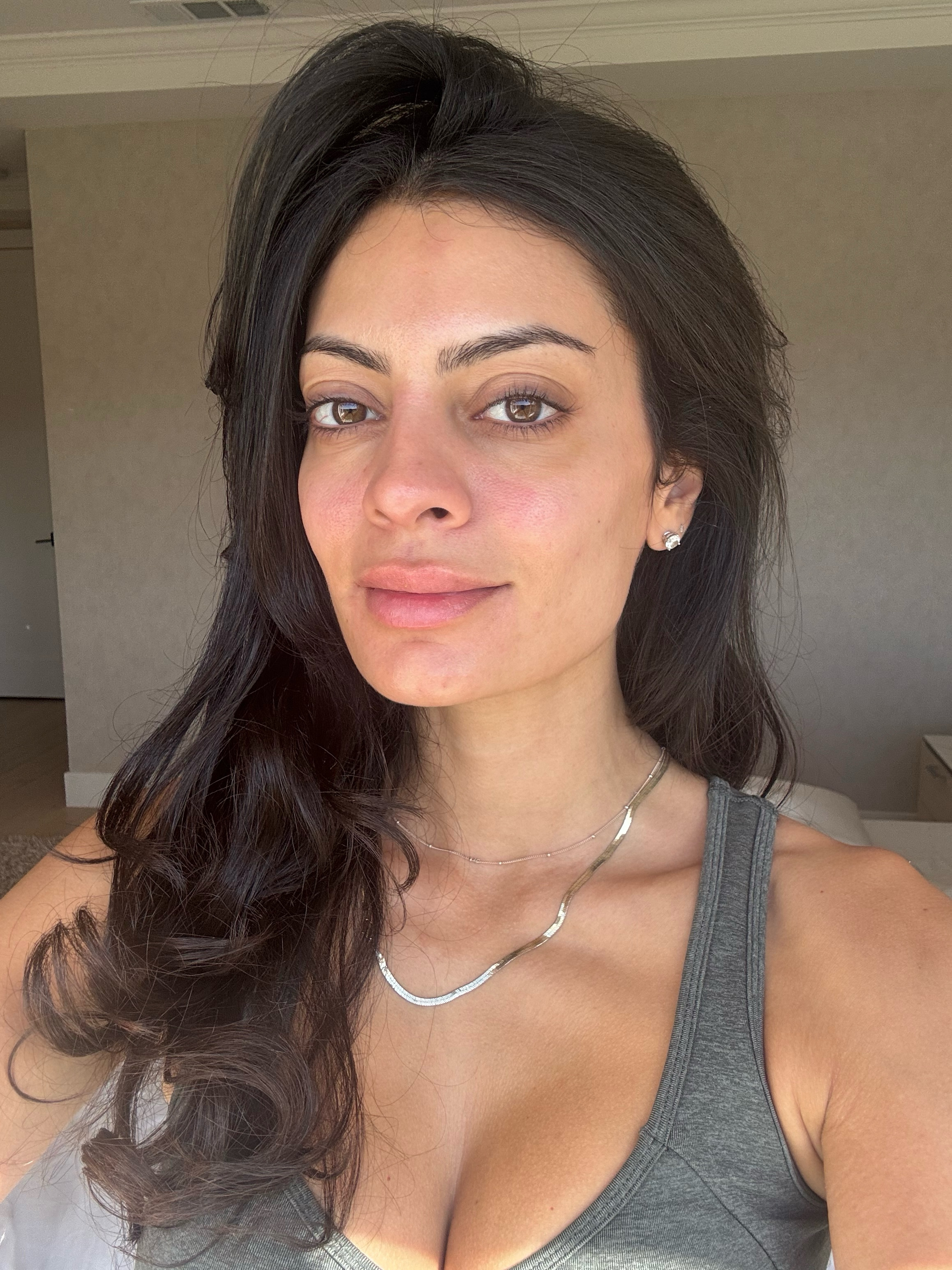 Michelle Rostamian, a woman with dark hair and dark eyes, with glowing skin