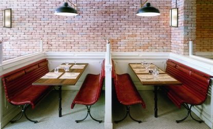 Interior of the Mozza Restaurant in Mote Carlo with brick walls, wooden tables and benches