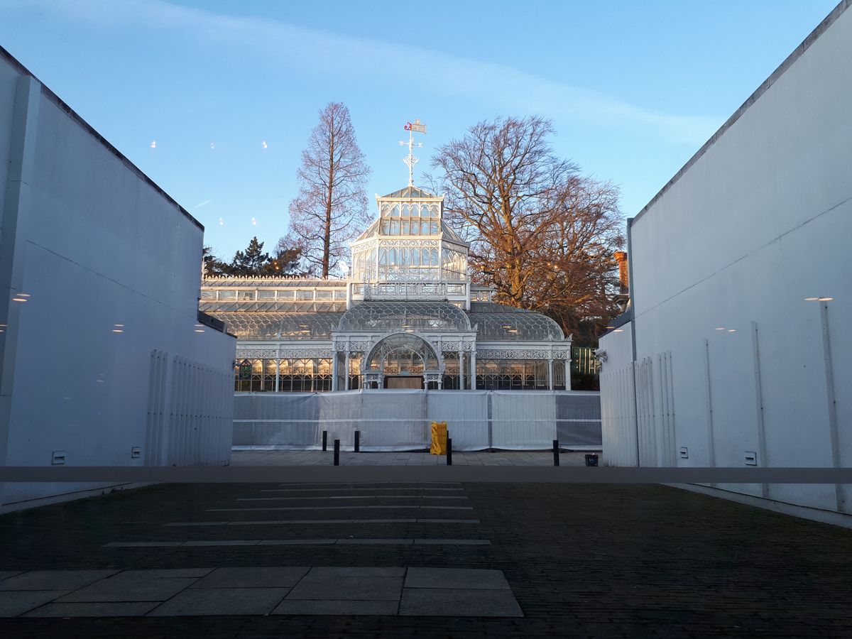 Even though this greenhouse only takes up a third of the photo, you can still make out the fine ornamentation of its metalwork close-up.