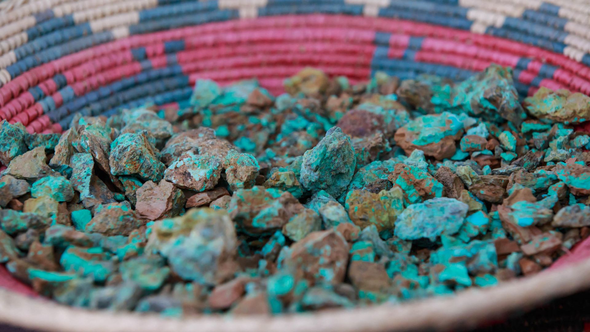 raw turquoise stones in a multicolored basket