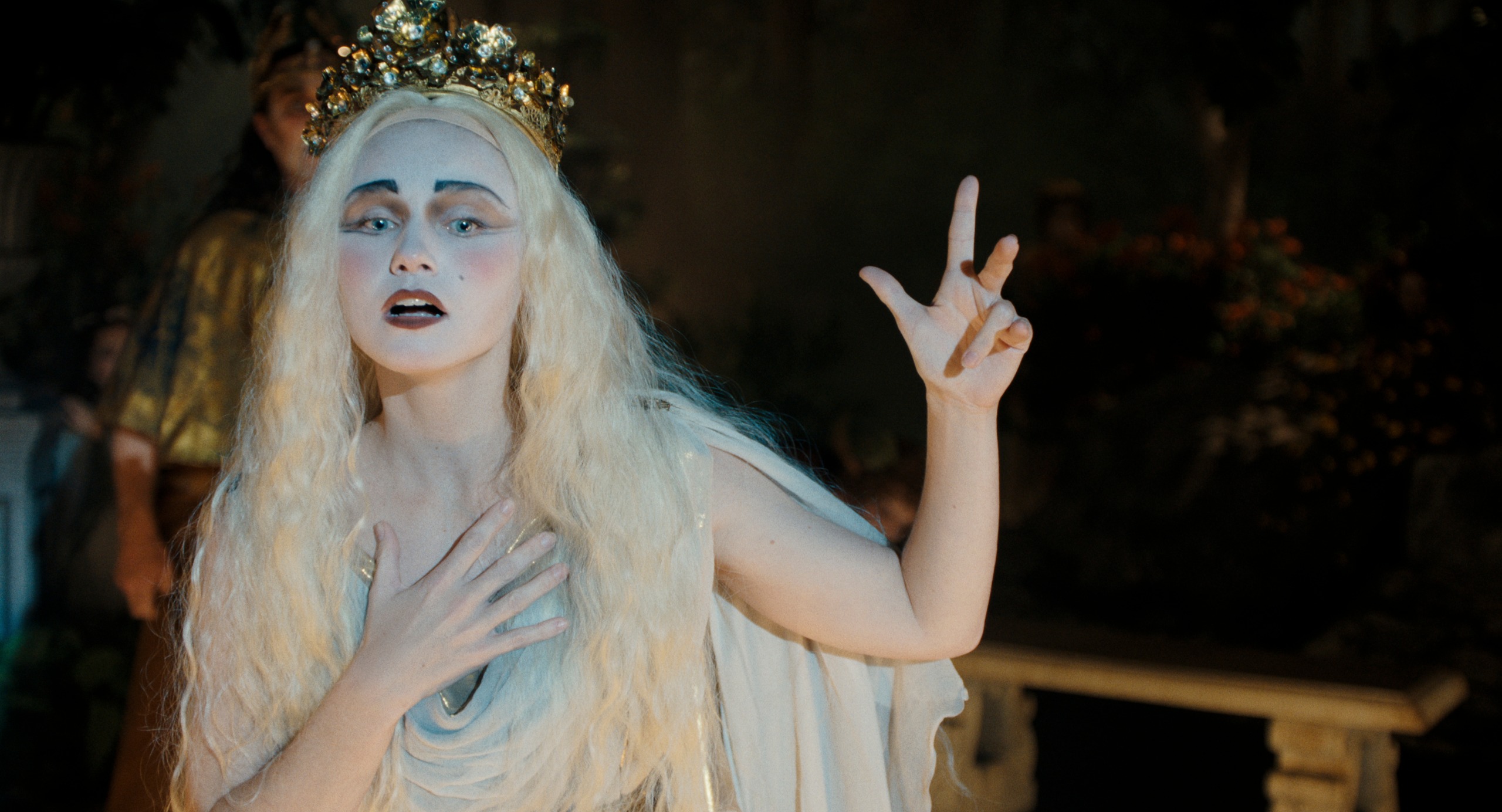 jessica barden as actress nance o'neil wearing white makeup and a blonde wig singing on stage in monster the lizzie borden story