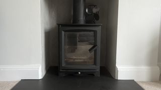forest master sf stove fan sitting next to flue on black wood burning stove