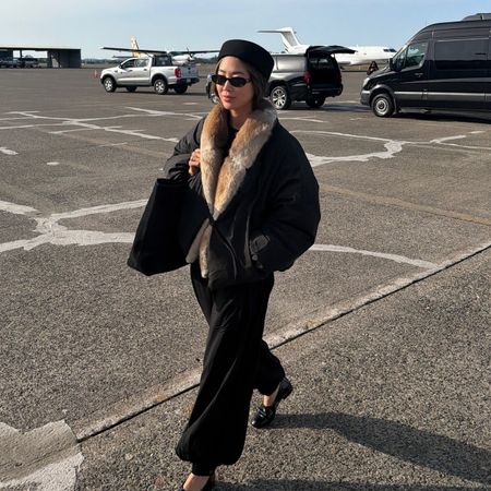 aimee song wearing a fur trim coat while traveling