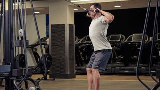 Man demonstrates the midway position of the face pull exercise using a cable machine