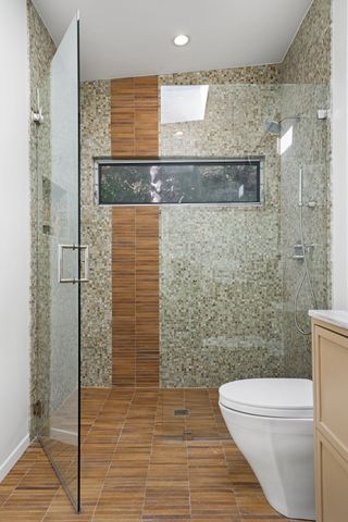 A modern shower room with mosaic and terracotta tiles