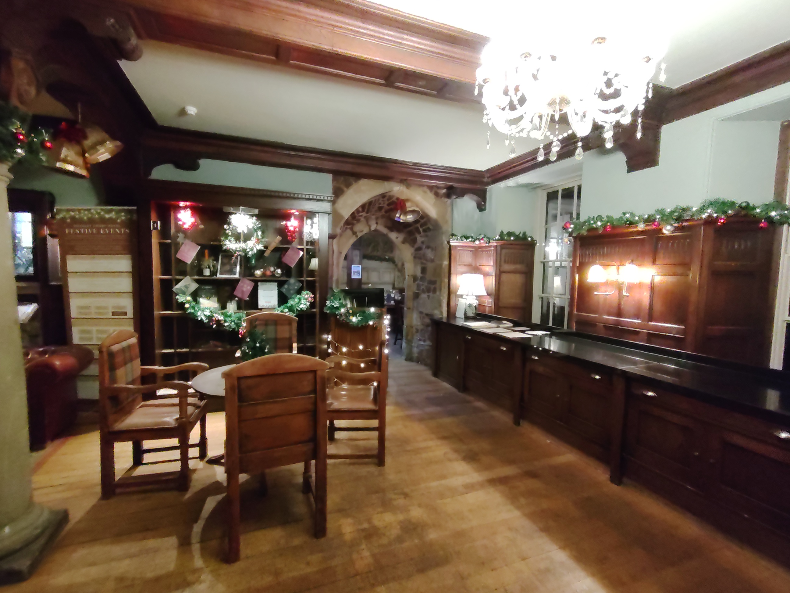 Interior of a pub with wooden table, chairs and chandelier