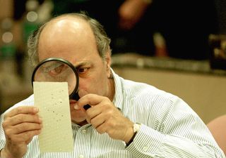 Punch cards have their issues. Here, Judge Robert Rosenberg of the Broward County Canvassing Board examines a dimpled chad on a punch-card ballot Nov. 24, 2000, during a vote recount in Fort Lauderdale, Florida. 