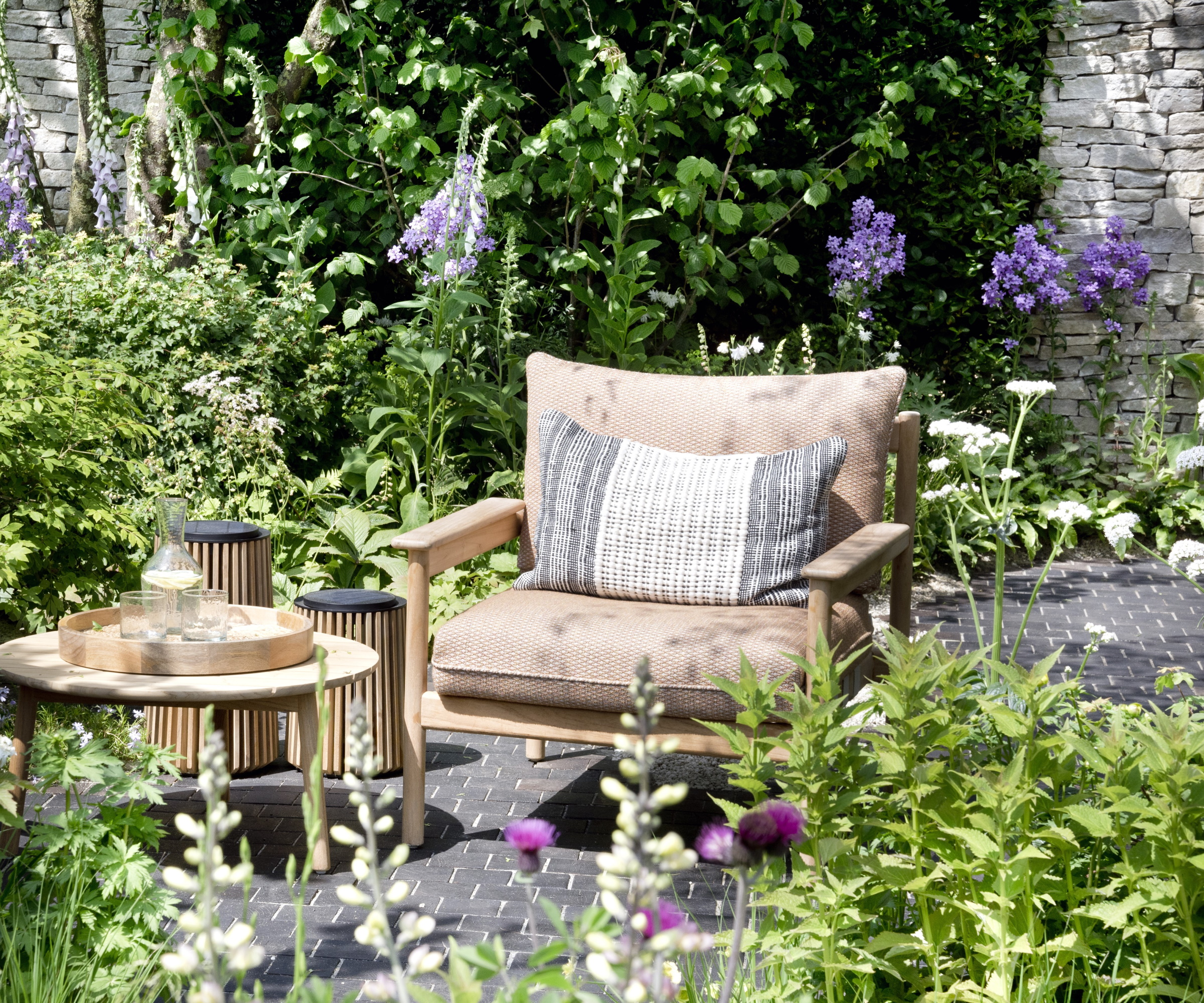 Patio armchair and table in a green, lush garden