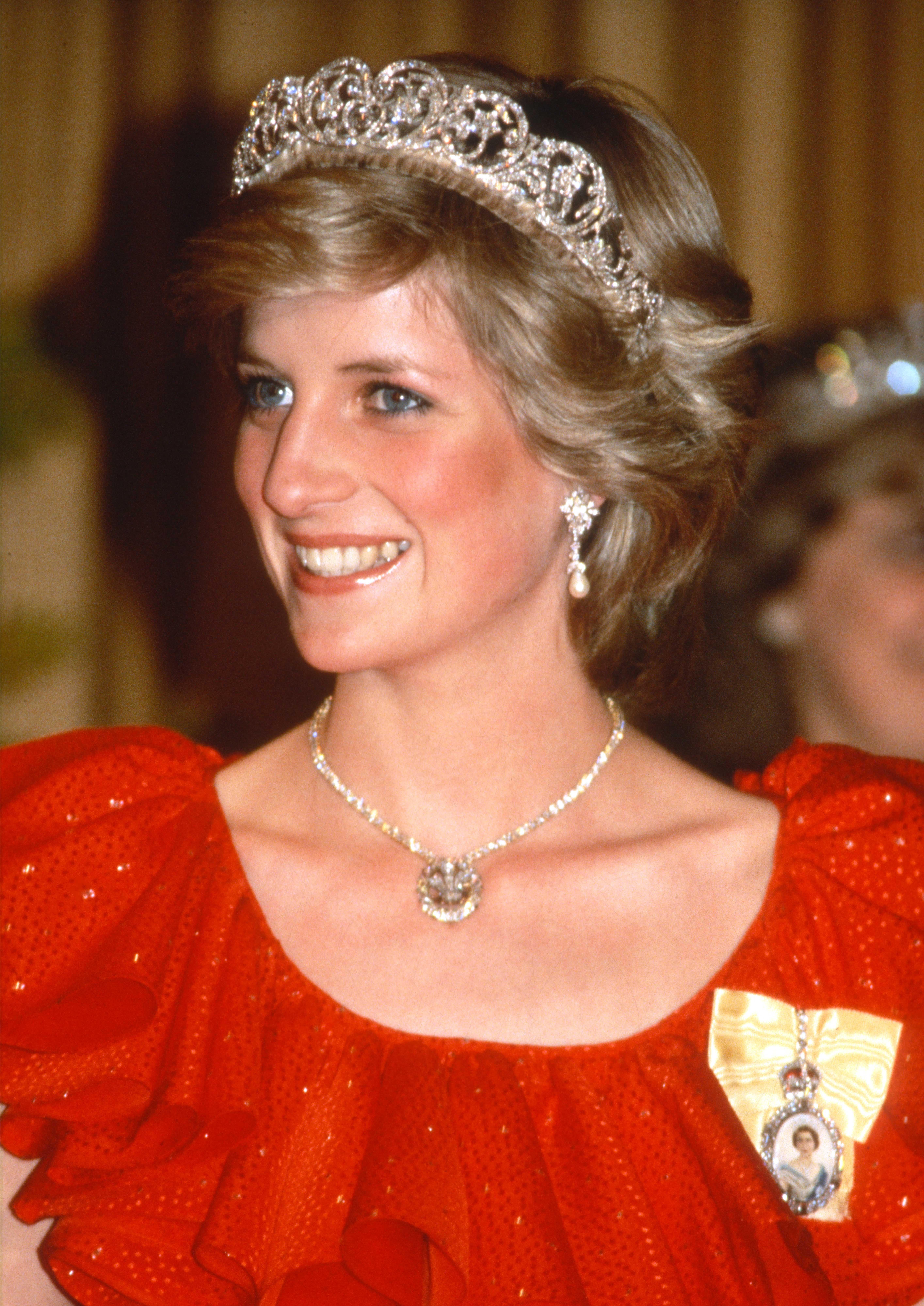 Princess Diana wears a red dress and the Queen Alexandra Three-Feather Brooch